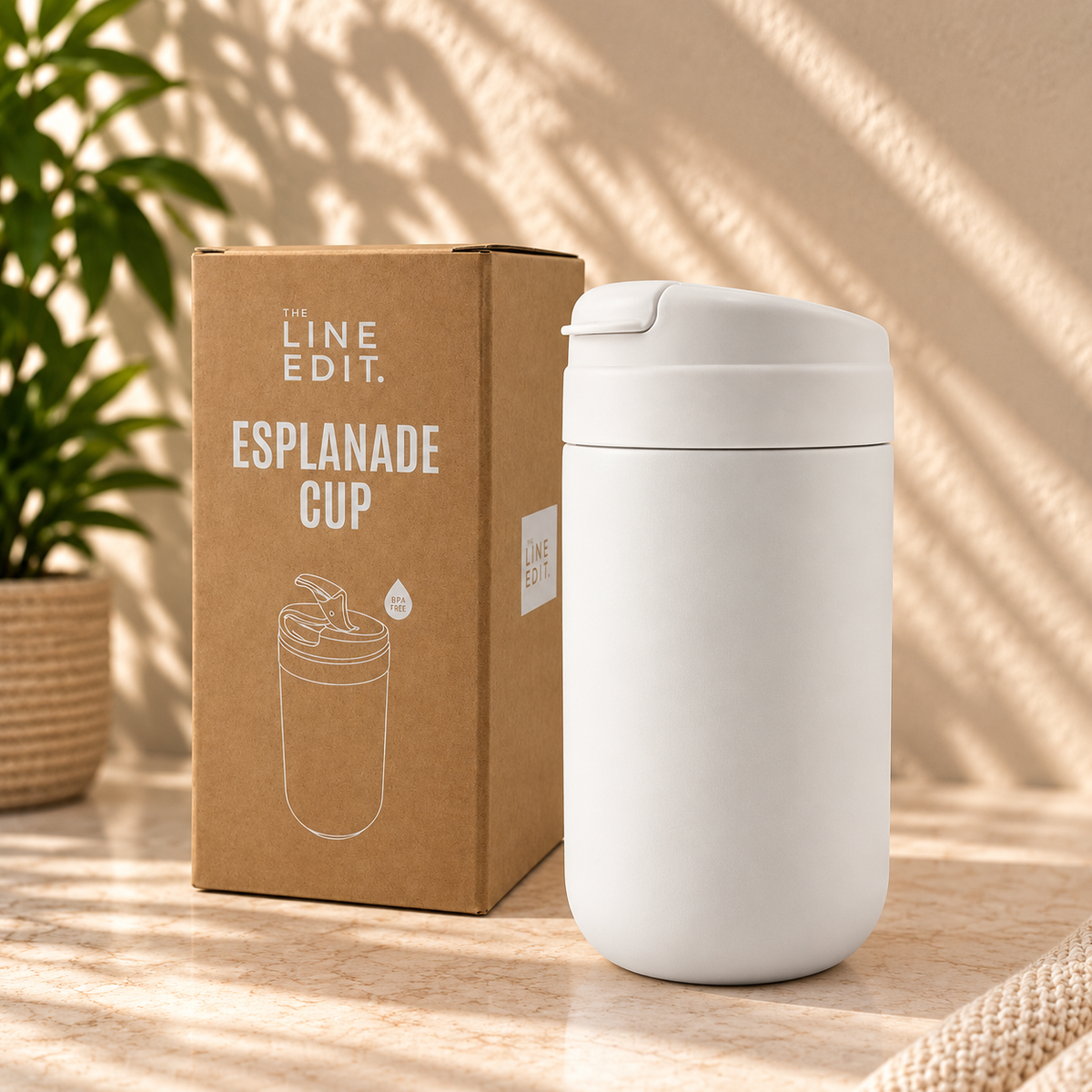 Esplanade reusable coffee cup in white by The Line Edit, shown with its kraft gift box