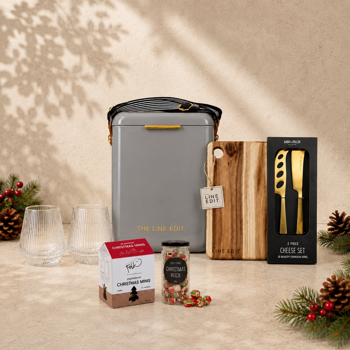 The Christmas Haul in grey — Pavilion cooler with an acacia serving board, gold cheese knife set, Velora tumblers and Christmas treats, styled with pine and pinecones