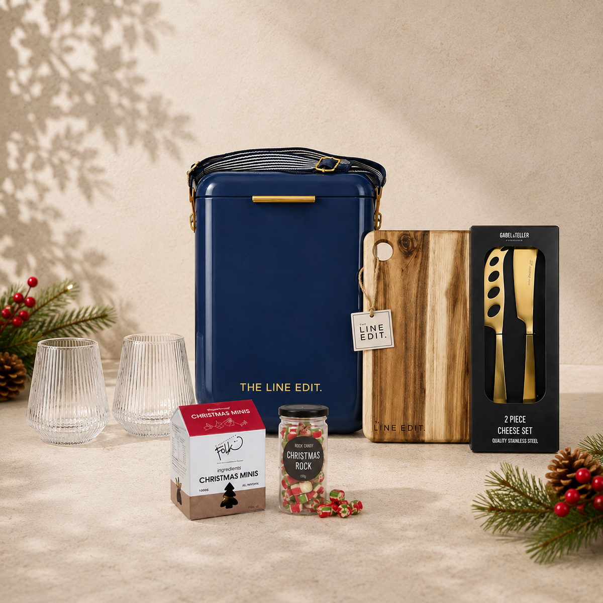 The Christmas Haul in navy blue — Pavilion cooler with an acacia serving board, gold cheese knife set, Velora tumblers and Christmas treats, styled with pine and berries