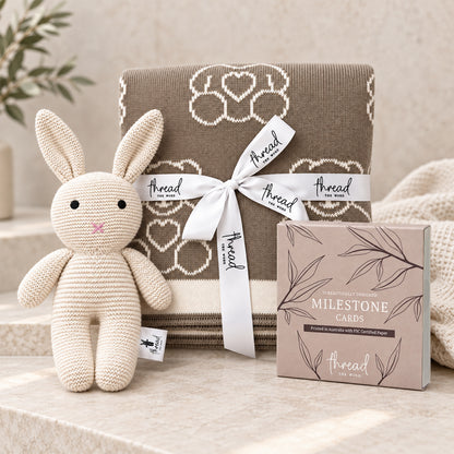 Eggshell baby gift set, teddy bear print blanket, cream knitted bunny and milestone cards gathered together
