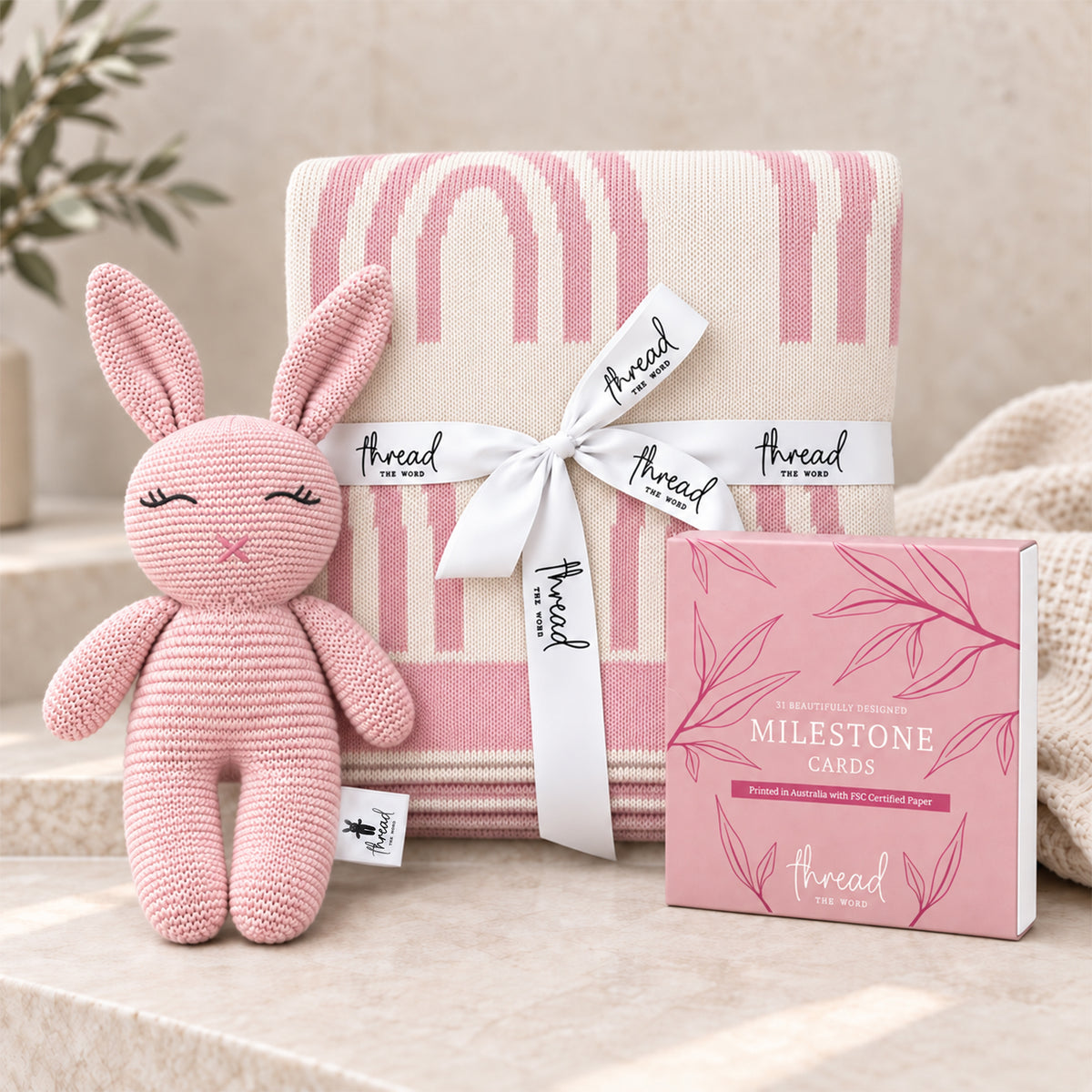 Pink baby gift set, rainbow print cotton blanket, pink knitted bunny and Thread the Word milestone cards
