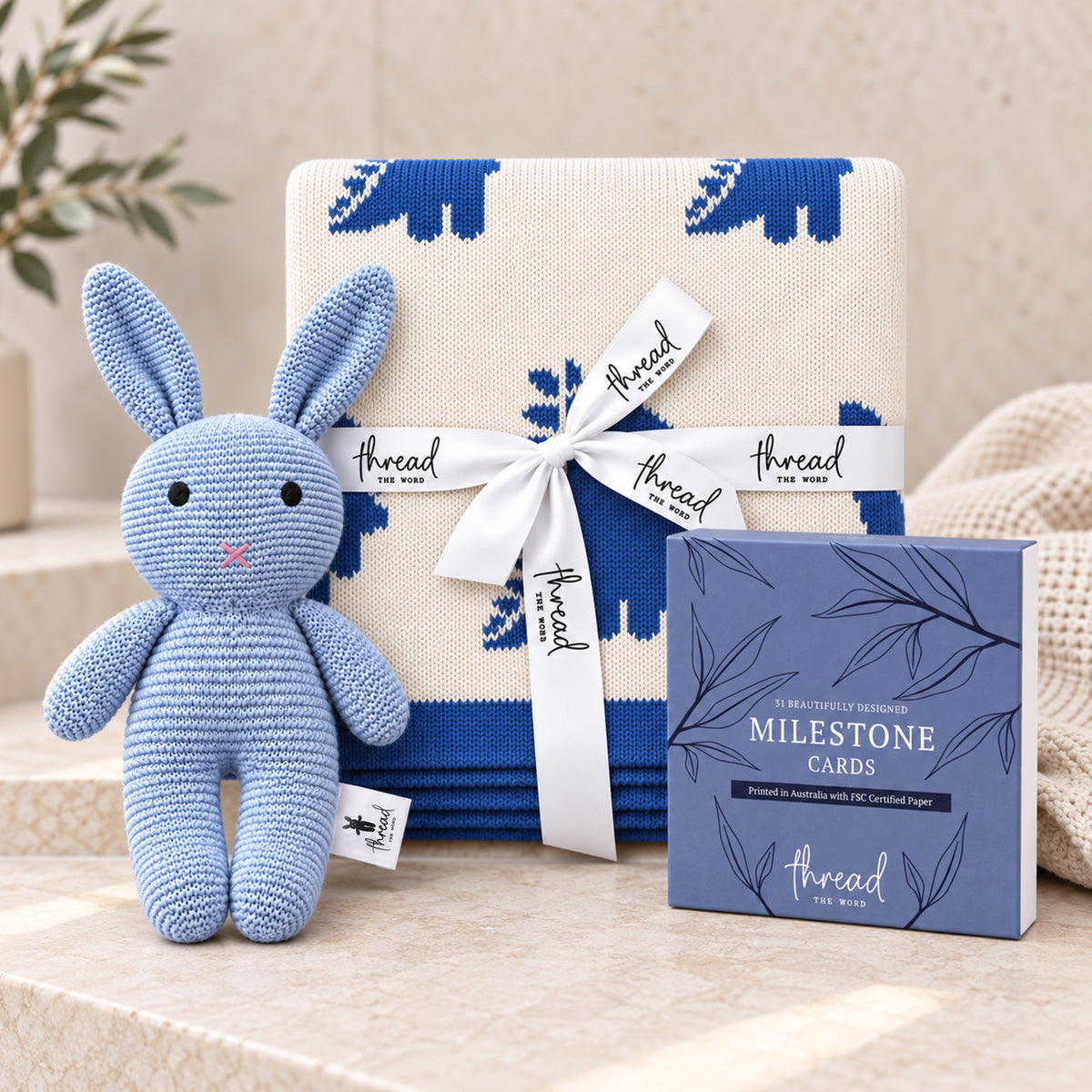 Seamist baby gift set, blue dinosaur print blanket, blue knitted bunny and Thread the Word milestone cards