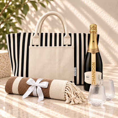 Sun and Sparkling gift hamper with a navy striped Hampton tote, Chandon sparkling, two fluted Velora tumblers and a Turkish towel tied with ribbon