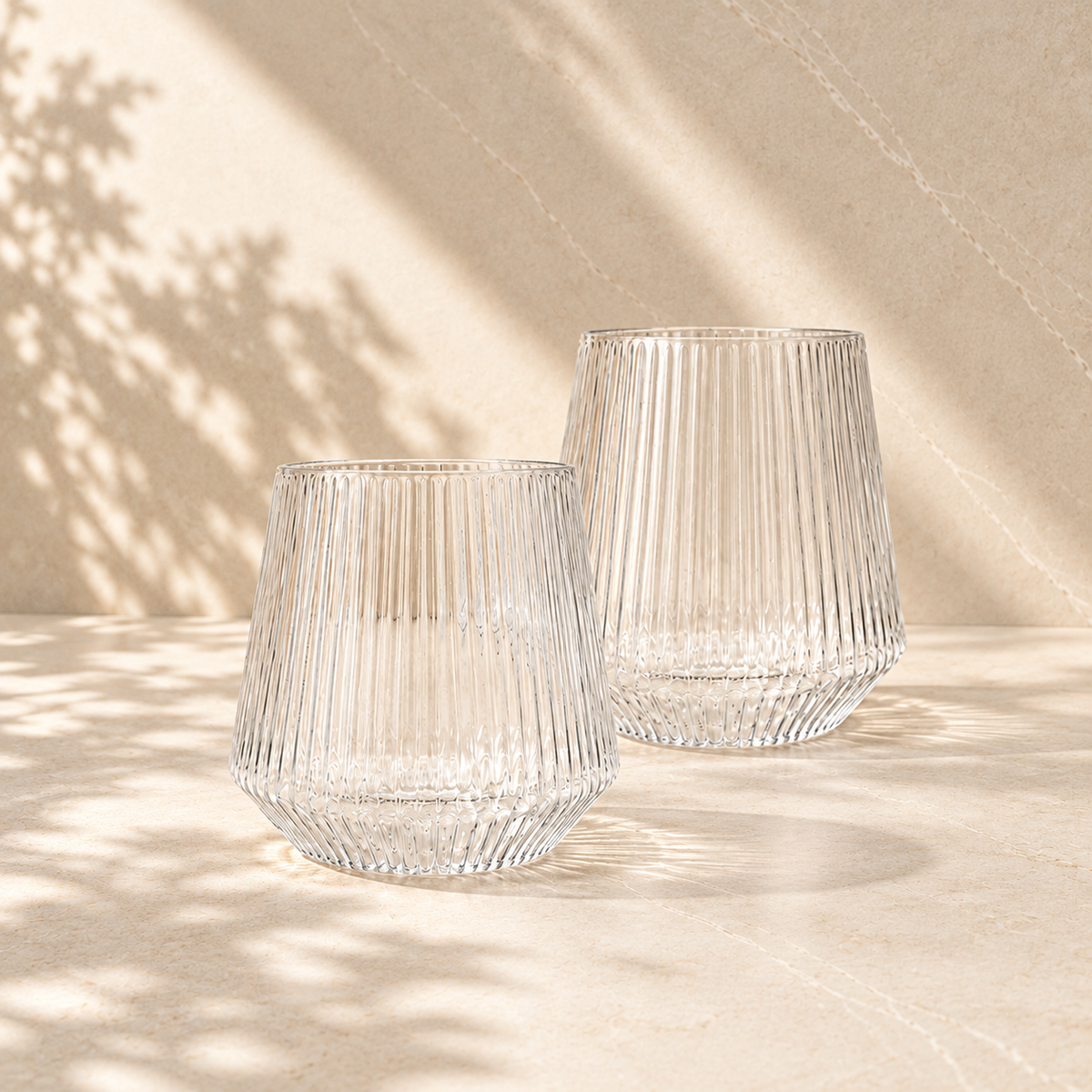Two clear fluted Velora tumblers from The Summer Duo, shatter resistant with a real glass look, in dappled afternoon light